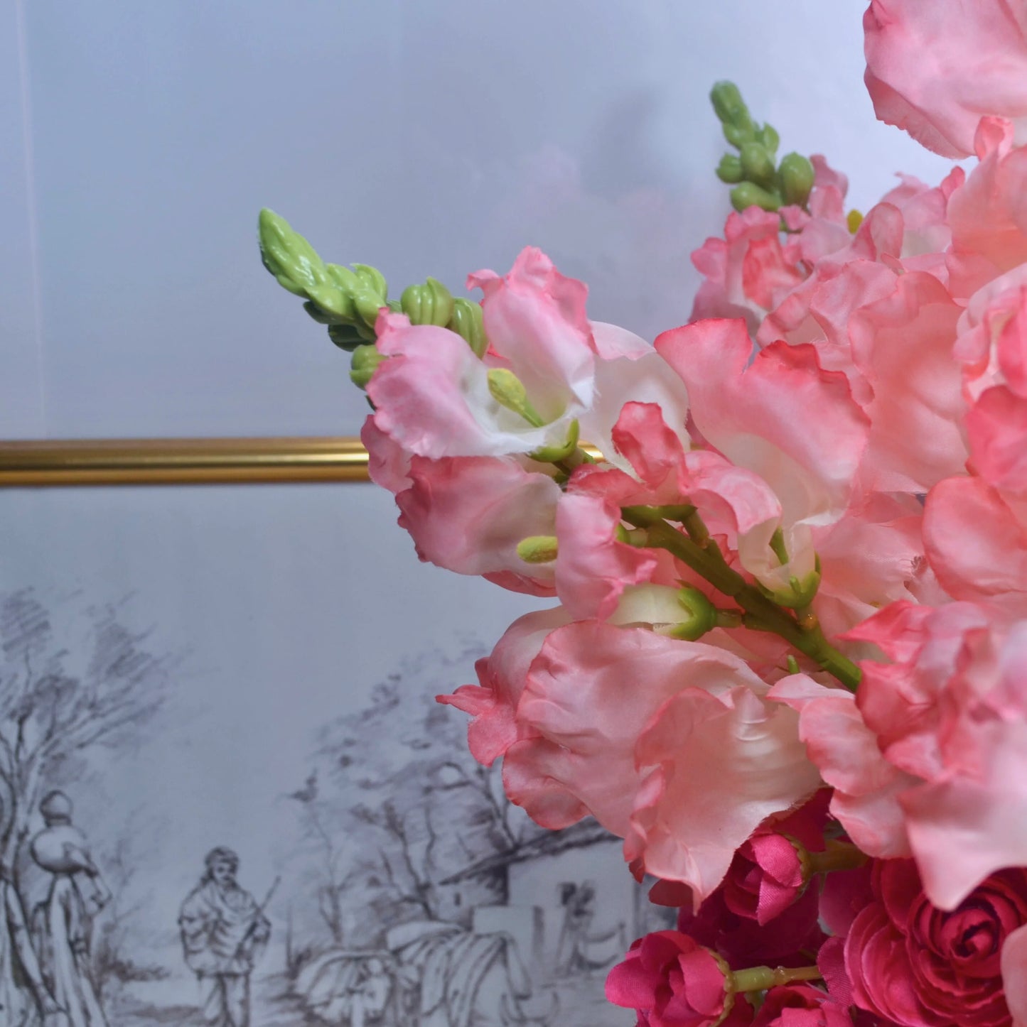 Close-up of pink flowers with a blurred background featuring a decorative plate.