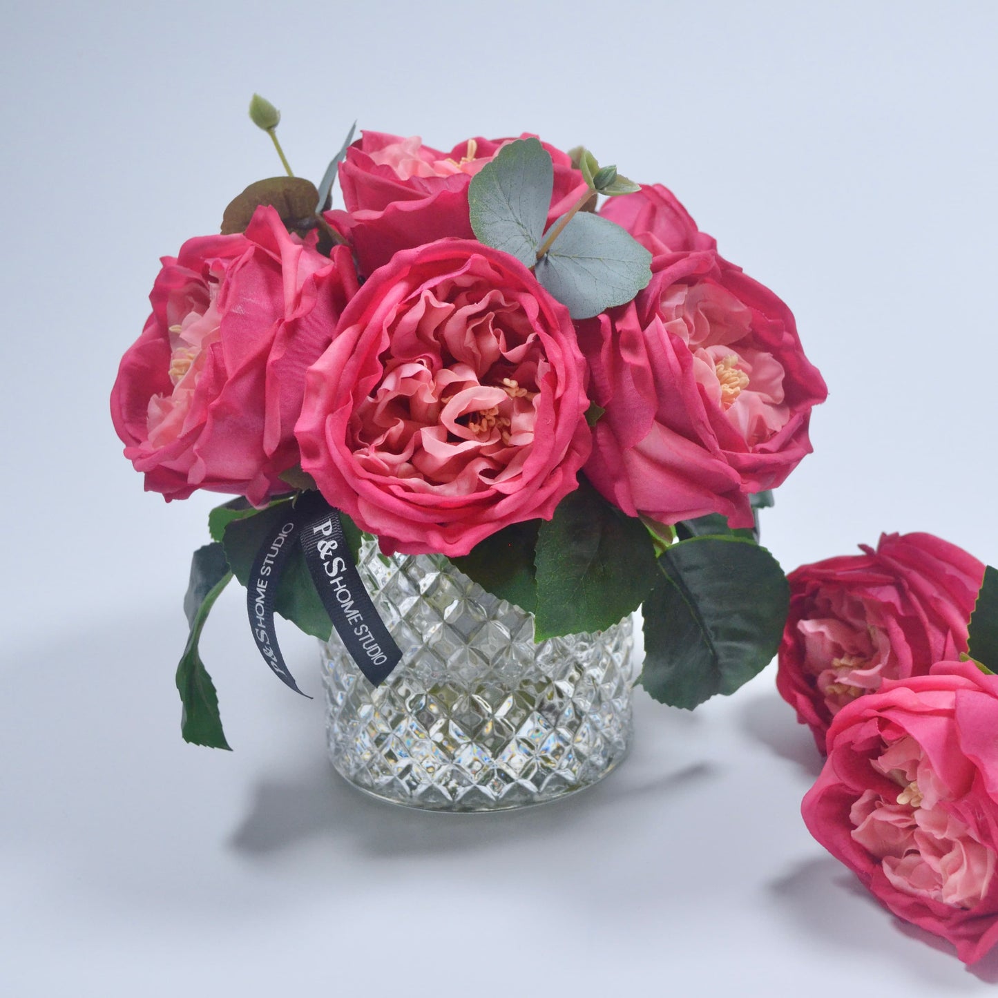 Bouquet of pink roses in a crystal vase on a light gray background