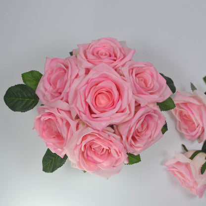 Bouquet of pink roses with green leaves on a light gray background