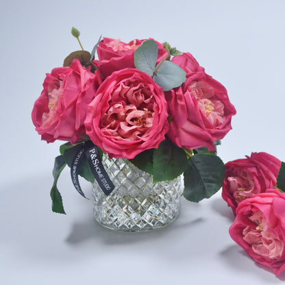 Bouquet of pink roses in a crystal vase on a light gray background