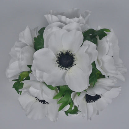 Bouquet of white flowers with green leaves on a gray background
