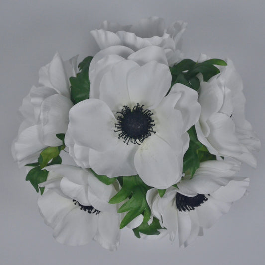 Bouquet of white flowers with green leaves on a gray background